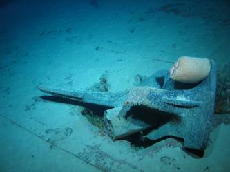 Stbd anchor embedded in steel plate from ship's side in debris field